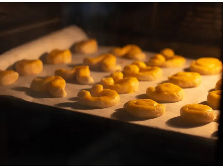 Cookies baking on a parchment-lined oven tray